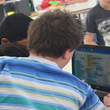 Grupo de chicos programando en Scratch durante una clase