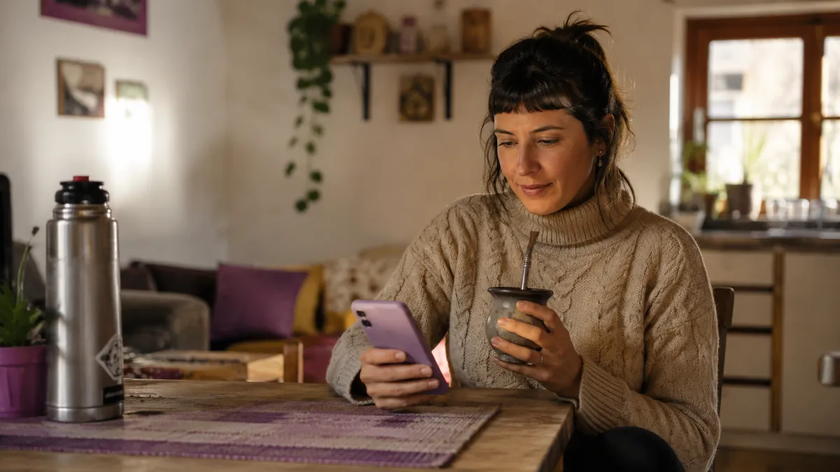 Mate sobre la mesa al lado de un celular con redes sociales abiertas