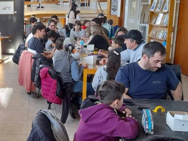 Familias construyendo y personalizando robots juntas en mesas compartidas